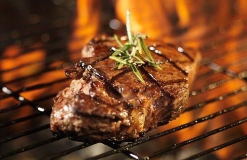 Juicy oak-fired steak sizzling on the grill at Alamo Steakhouse, a top Gatlinburg restaurant for hand-cut Texas-style steaks