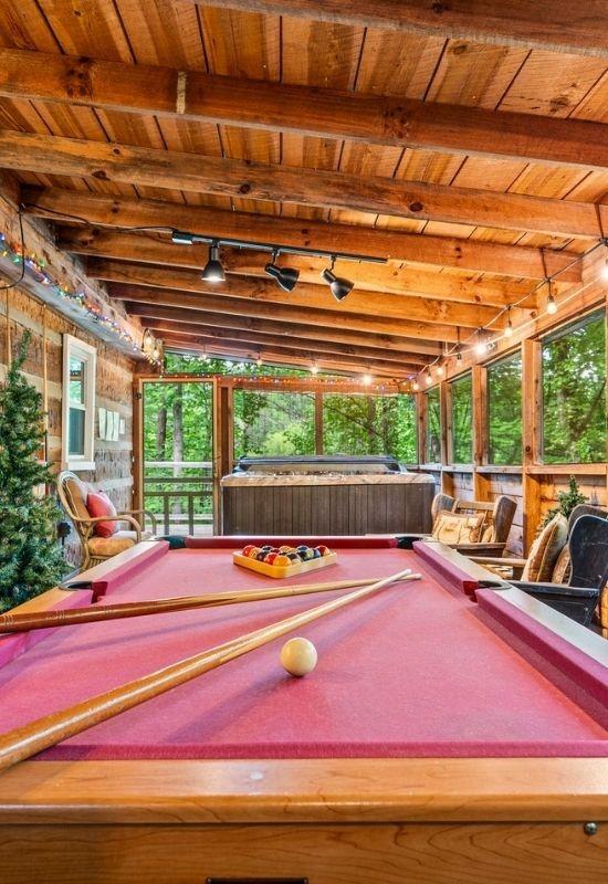 Fly Away is a Pigeon Forge cabin with a pool table, hot tub, fire pit, and convenience!